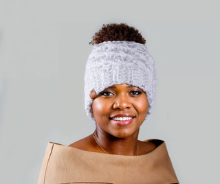 Woman wearing a white satin lined ponytail beanie. Messy bun hat.